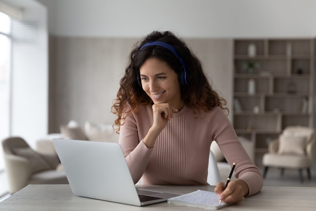 Woman smiling at computer screen